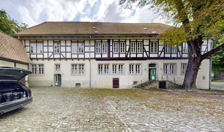 Historischer Eingangsbereich im Innenhof der Wasserburg Gebhardshagen – Originalfoto mit Natursteinfassade und Zugangssituation.