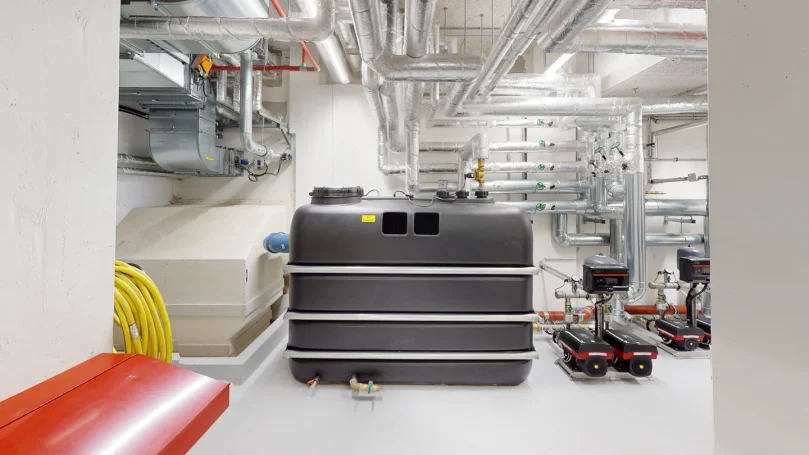 Technischer Anlagenraum mit Tanks, Rohrleitungen und Maschinen aus anderer Perspektive als digitaler Zwilling für TGA Planung